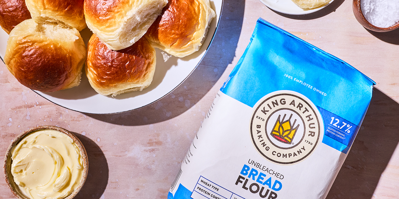 Make ahead dinner rolls on a counter with some butter and a bag of King Arthur Bread Flour