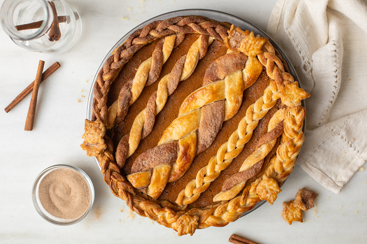 A pumpkin pie with braided strips and cinnamon-twists on top for decoration