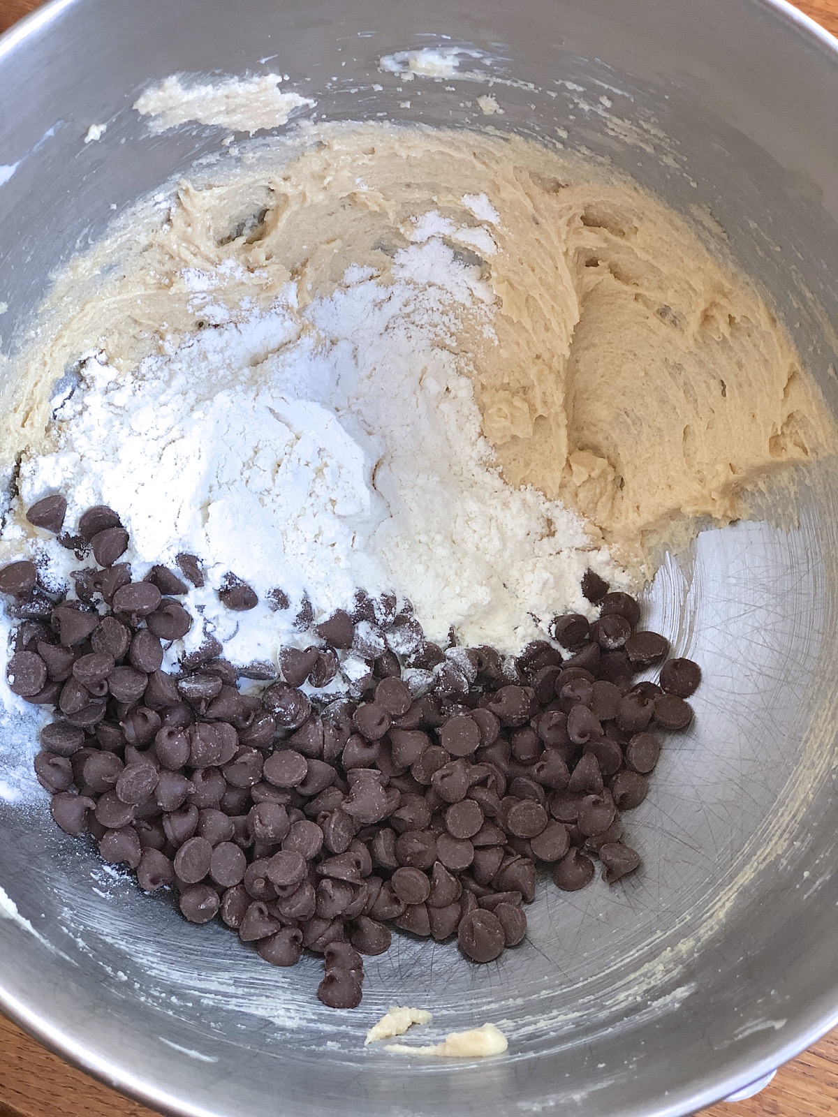 Miing flour and chocolate chips into the remaining dough for chocolate chip cookies.