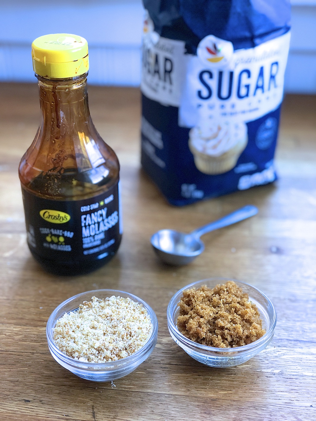 Small bowls of white sugar to which molasses has been added, showing how to make brown sugar from white sugar.