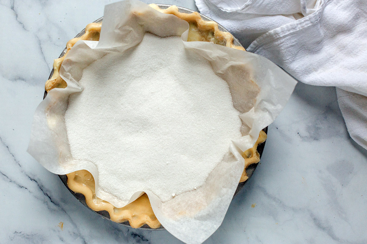 Single pie dough, unbaked, lined with parchment paper and weighed down with sugar