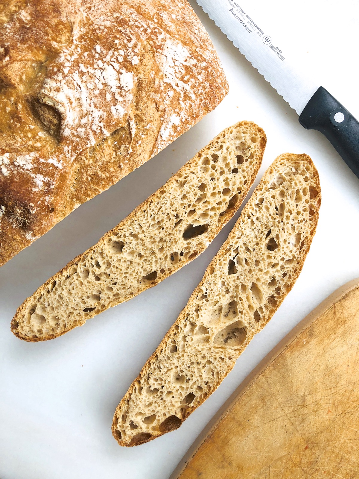 Sourdough bread on a marble slab, two slices cut.