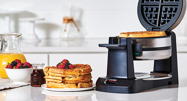A stack of waffles on a plate next to the Cuisinart Belgian Waffle Maker