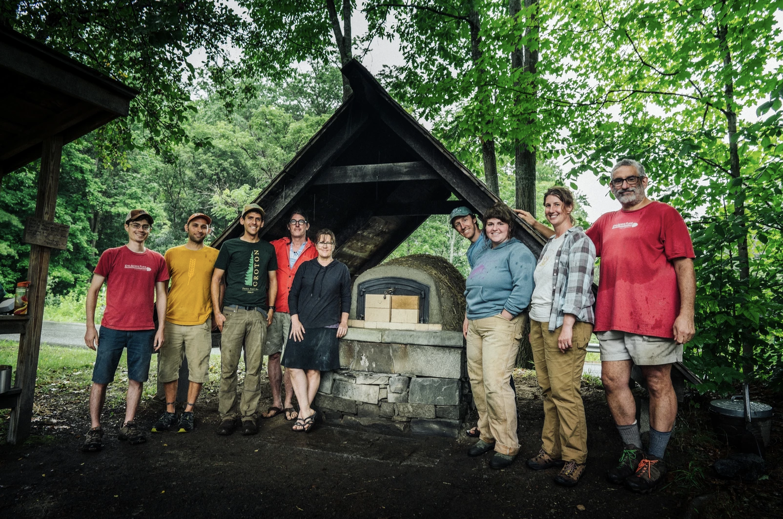 King Arthur volunteers standing around mud oven they built