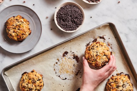 Baker picking up scones baked on a parchment-lined baking sheet