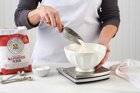 Baker weighing flour with a scale