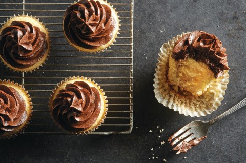 Vanilla cupcakes topped with chocolate frosting and filled with pastry cream