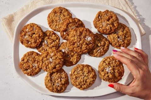 An overhead photo of Oatmeal Cookies on an oval platter for serving. The cookies have crackly tops and flaky sea salt sprinkled on them. - select to zoom