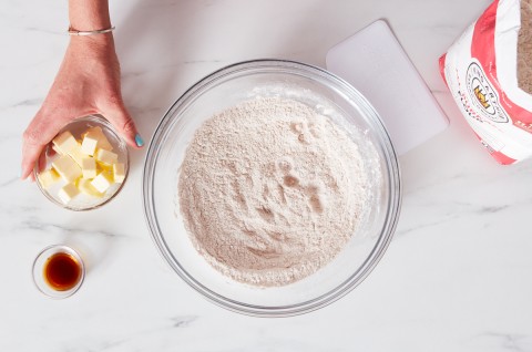 Bowl of flour next to bag of flour and small bowl of cubed butter