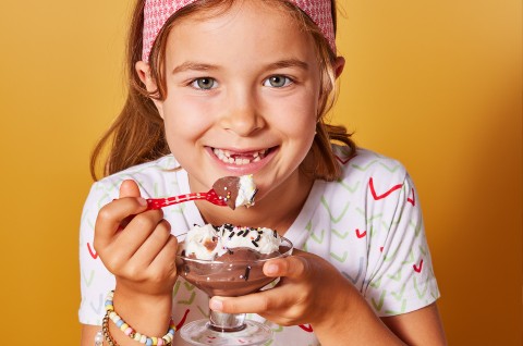 A little girl eating chocolate pudding
