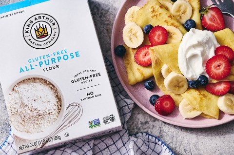 Gluten-Free Crêpes on a plate with berries and cream next to a box of gluten-free flour - select to zoom