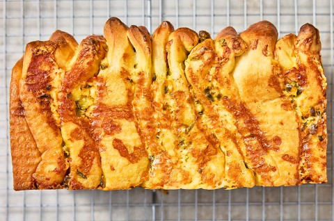 A loaf of Jalapeño-Cheddar Pull-Apart Bread on a cooling rack - select to zoom