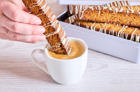 A piece of Gingerbread Biscotti being dipped into coffee - select to zoom