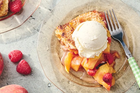 A slice of Peach Galette on a plate with a scoop of vanilla ice cream - select to zoom