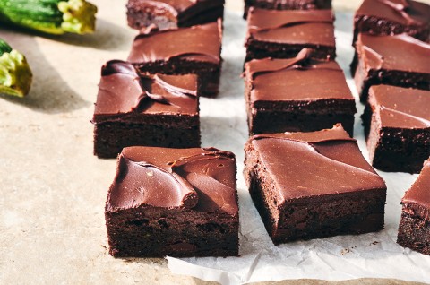 Zucchini Brownies cut into pieces and on a counter - select to zoom