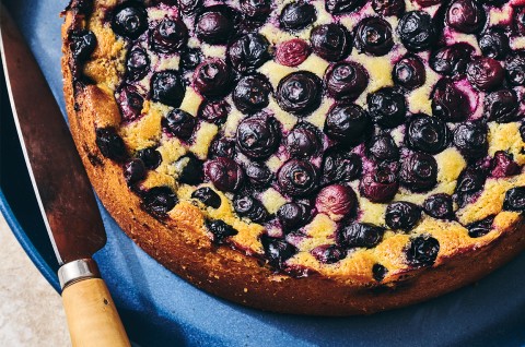 An uncut Blueberry Breakfast Cake on a plate - select to zoom