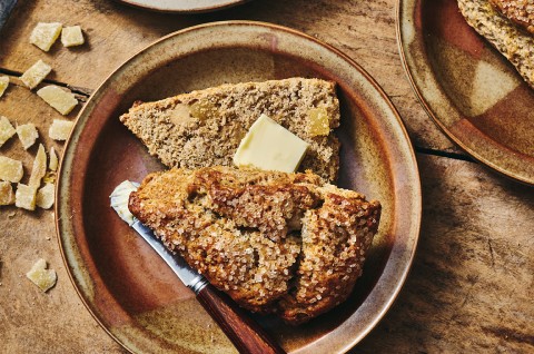 A Ginger Scone cut in-half and with a pad of butter - select to zoom