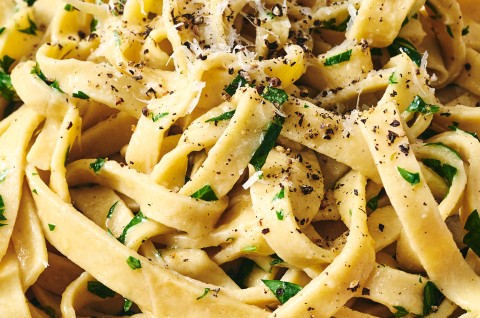 Detailed photograph of gluten free pasta with cracked pepper, parmesan, and herbs. - select to zoom