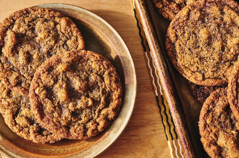 Overhead view of Cape Cod Soft Molasses Cookies shown on a plate and also on a baking sheet. - select to zoom