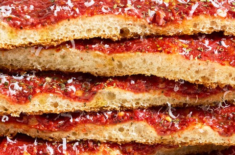 Detailed side photo of a stack of Rhode Island Pizza Strip slices. - select to zoom