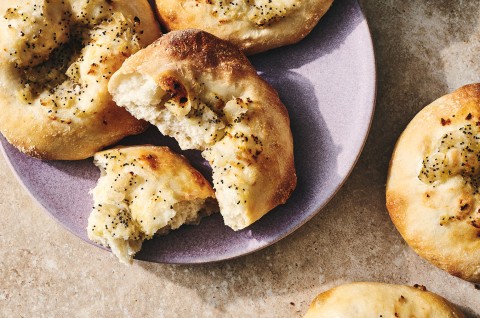 Classic Bialys on a plate with one broken apart to show the chewy interior. - select to zoom