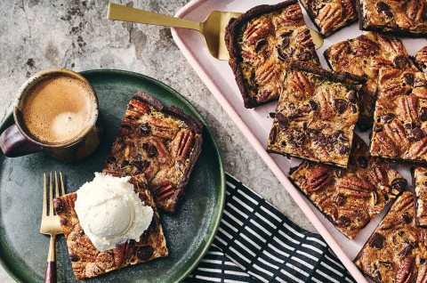 Two slices of Slab Chocolate Pecan Pie on a plate and one has vanilla ice cream on top. - select to zoom
