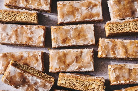 Lebkuchen Bars on a sheet tray arranged imperfectly and showing the gingerbread interior and glazed top. - select to zoom