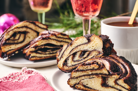 Slices from a chocolate babka wreath on a table setting. - select to zoom