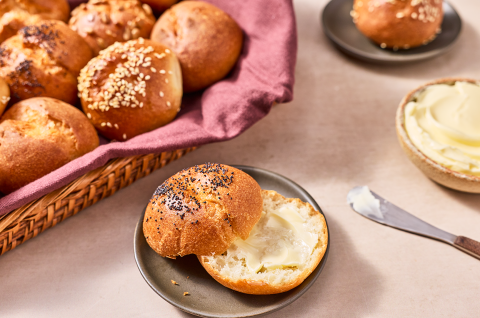 Various gluten-free buns and rolls shown in a basket and on plates. - select to zoom