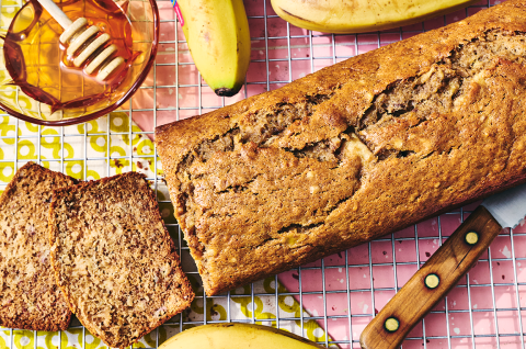 A loaf of Sourdough Banana Bread on a countertop with two pieces sliced and laying on their side. - select to zoom