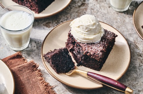 Chocolate Olive Oil Cake topped with vanilla ice cream and a bite on a fork. - select to zoom