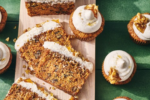 Spiced Carrot Snacking Cake on a cutting board with cupcakes around it. - select to zoom