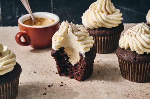 Detailed shot of an Irish Cream Cupcake sliced in half to show the frosting in the center as well as on top. - select to zoom