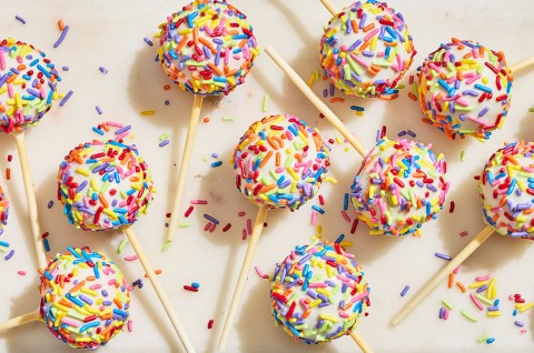 Confetti Cake Pops on a countertop seen from above. - select to zoom