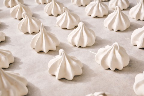 Meringue Kisses in neat rows on a counter. - select to zoom