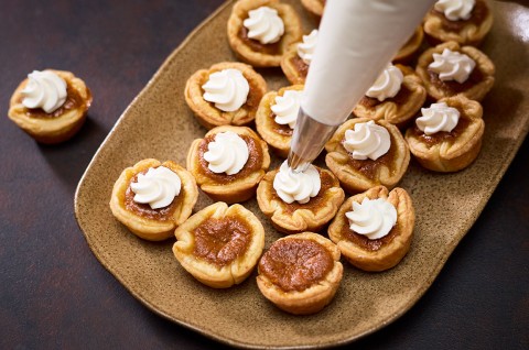 Adding whipped cream to the top of Mini Pumpkin Pies - select to zoom