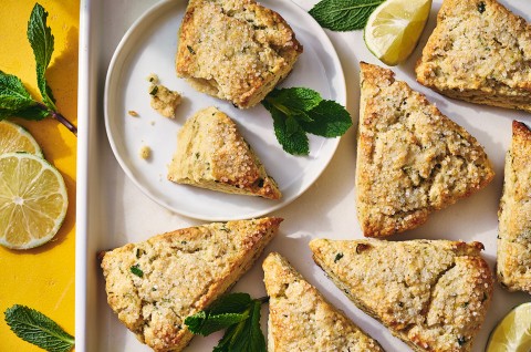 Mojito Scones on a plate and a platter with limes and mint leaves decorating the photo. - select to zoom