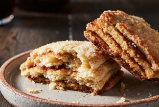 A Layered Fig Scone on a plate, broken in half, to reveal stripes of fig jam.