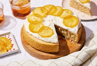 A simple, single layer lemon cake topped with frosting and candied lemon slices