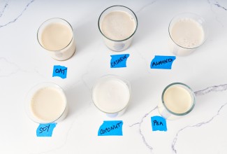 Six glasses of non-dairy milk next to each other