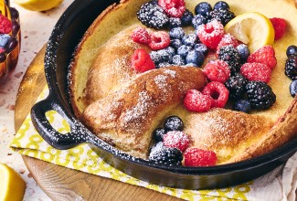 Lemon Puff Pancake with Fresh Berries in a cast iron pan