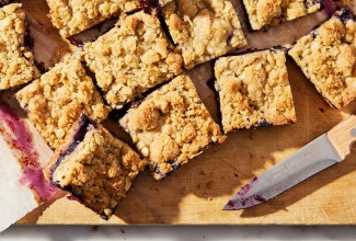 Sliced fruit bars on a cutting board next to a knife