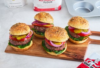 Four Hamburgers on a cutting board