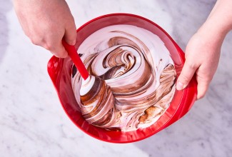 Folding cake batter in red mixing bowl