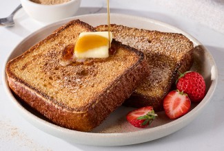 Brioche French Toast on a plate with butter and maple syrup