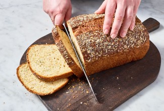 Slicing a loaf of Multigrain Protein Bread.