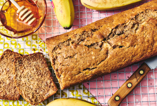 A loaf of Sourdough Banana Bread on a countertop with two pieces sliced and laying on their side.