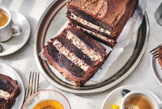 Chocolate Cassata Cake on a plate with a slice laying down showing layers of chocolate and creamy filling.