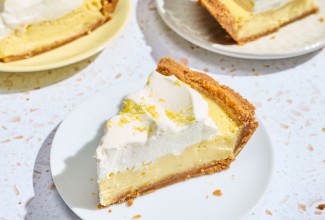 A slice of Lemon Cream Pie on a white plate.
