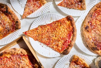 Slices of New York-Style Pizza paper plates arranged on a table seen from above.